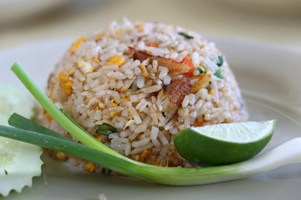 Reis schmackhaft zum Ball geformt Reis mit gebratenen Kochbananen und frittierten Hühnchenteilen