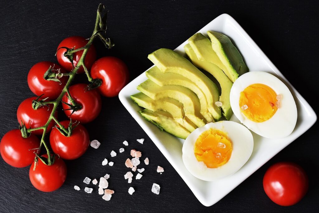 schmackhafte Lebensmittel serviert Tomaten Eier Avocados Ketogene Diät Rezepte zum Frühstück